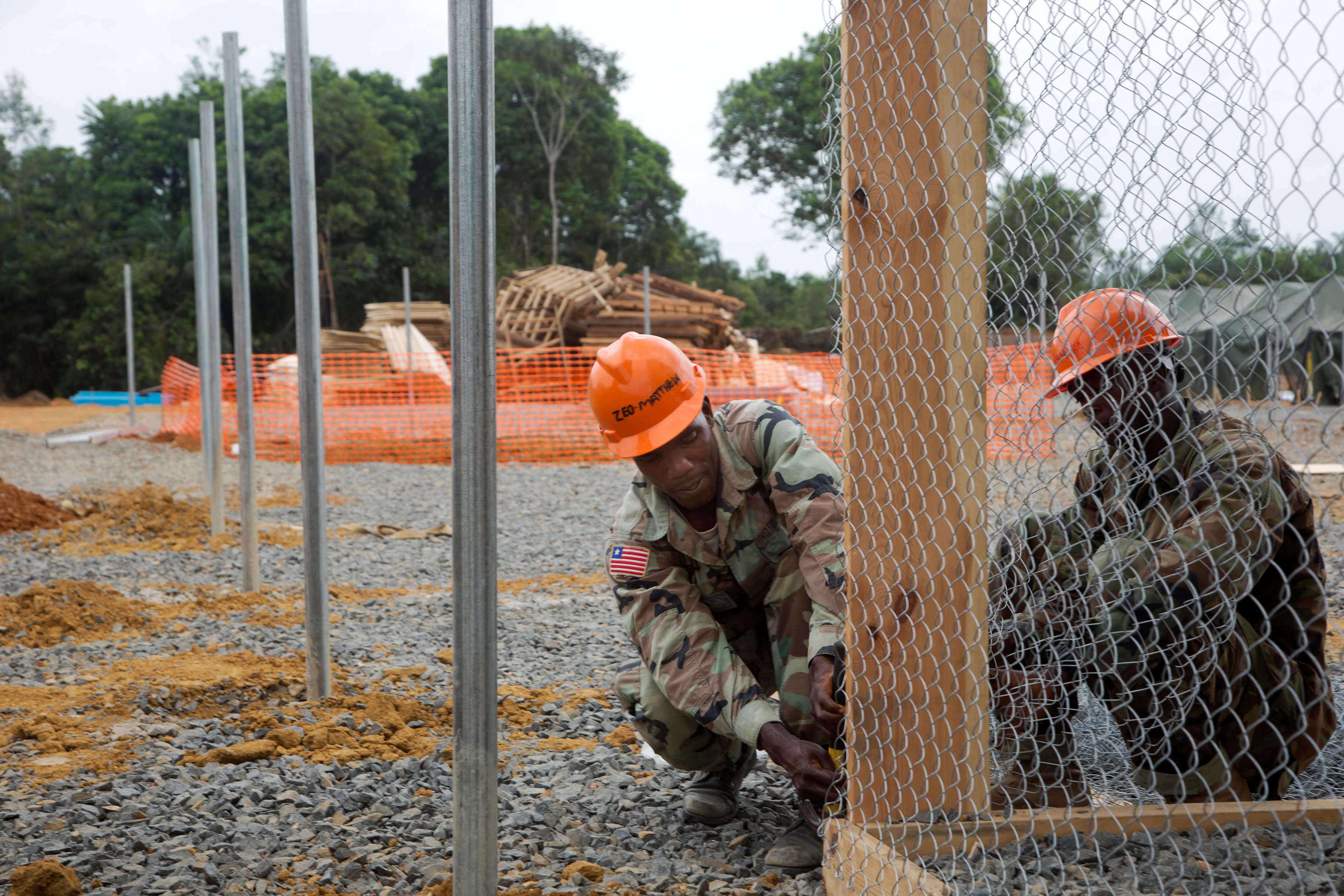 Liberian Soldiers attach fencing at an Ebola treatment unit being built in support of Operation United Assistance in Gbediah, Liberia, in December 2014. United Assistance was the DOD operation to provide command and control, logistics, training and engineering support to U.S. Agency for International Development-led efforts to contain the Ebola virus outbreak in West Africa. (U.S. Army photo by Sgt. 1st Class Brien Vorhees, 55th Signal Company (Combat Camera))