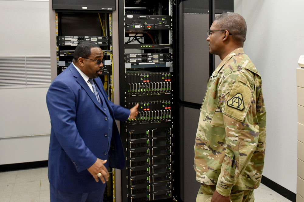 Ralph Edmonds, left, showcases a portion of Fort Belvoir’s LMR equipment to Brig. Gen. Patrick W. Burden, program executive officer for Enterprise Information Systems (EIS). In 2014, PEO EIS’ LMR Product Office began developing a plan to address a handful of threats to the readiness of Army LMR systems in the U.S., including a complex requirement, only two suppliers, and a shrinking pool of appropriated funds. (PM DCATS photo by James Christophersen)