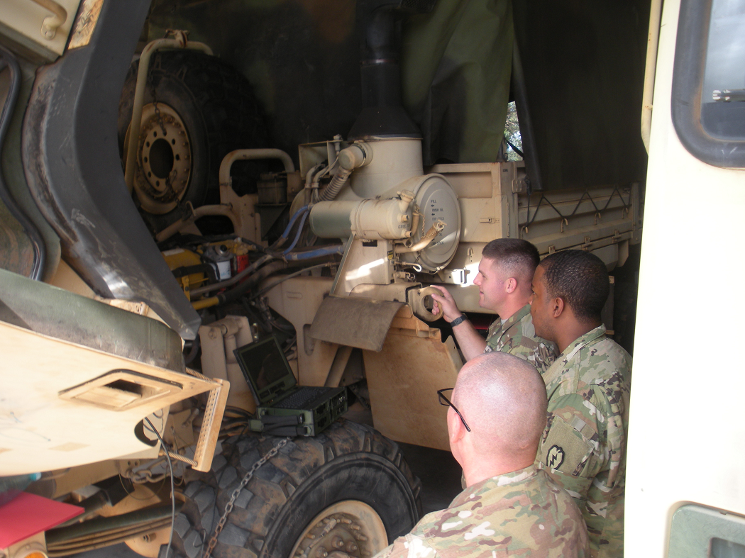 Soldiers from 25th Transportation Company utilizing diagnostics tools and software on M1083 FMTV, Schofield Barracks, HI, December 2015. Photo by Mr. Jesse Fields, AMSAA Operational Sustainment Analysis Team.
