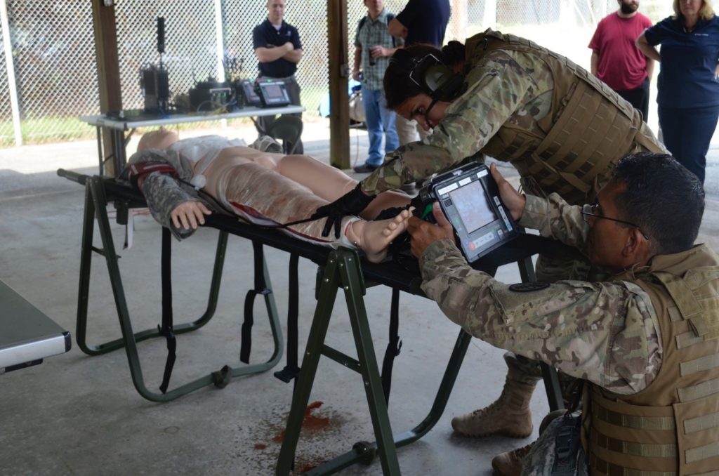 Field medics perform a simulated escharotomy using the Remote Diagnostic Technologies i2i Solution (Tempus Pro) at TATRC, Fort Detrick, Sept. 7. (Photo by Elizabeth Lamie, USAMRMC Public Affairs)