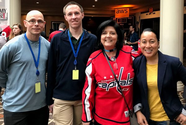 TWI and Education with Industry (EWI) fellows attend an Amazon Web Services business conference in Tysons Corner, Virginia, on Sept. 27. From left are Maj. Chris Ehlers, Army operations research analyst and TWI fellow; Staff Sgt. Robert Staal, Air Force EWI fellow; Dalila Wortman, Amazon Web Services; and Maj. Desiree Dirige, Army acquisition TWI fellow. (Photo courtesy of Maj. Desiree Dirige)