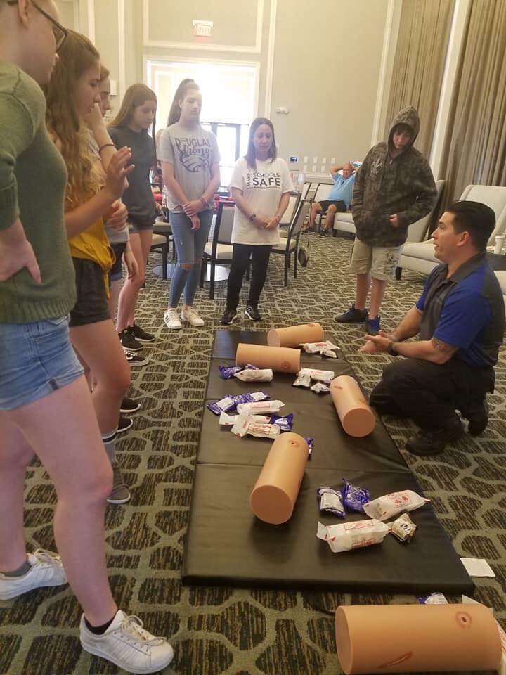 An instructor with “Stop the Bleed” licensee Blue Spear Solutions LLC teaches bleeding control techniques in July to students from Marjorie Stoneman Douglas High School in Parkland, Florida. Blue Spear has worked with students and families at the school, where a mass shooting on Feb. 14, 2018, killed 17 people and injured another 17. An effort is underway in the Florida Legislature to mandate the “Stop the Bleed” campaign in every school in the state. (Photo courtesy of Gregory Tony, Blue Spear Solutions LLC)