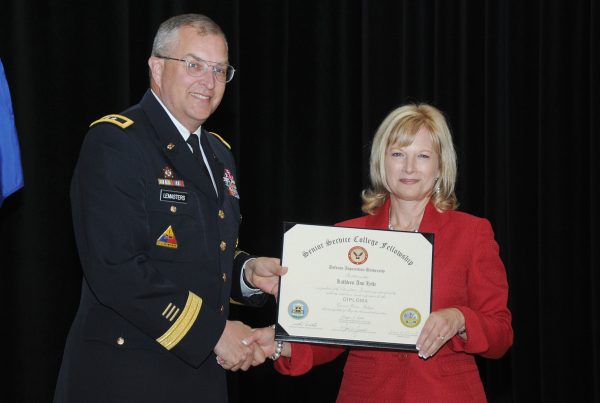 Maj. Gen. Clark W. LeMasters Jr., former Commanding General of the U.S. Army Tank-automotive and Armaments Command (TACOM), presents SSCF diploma to Lytle.