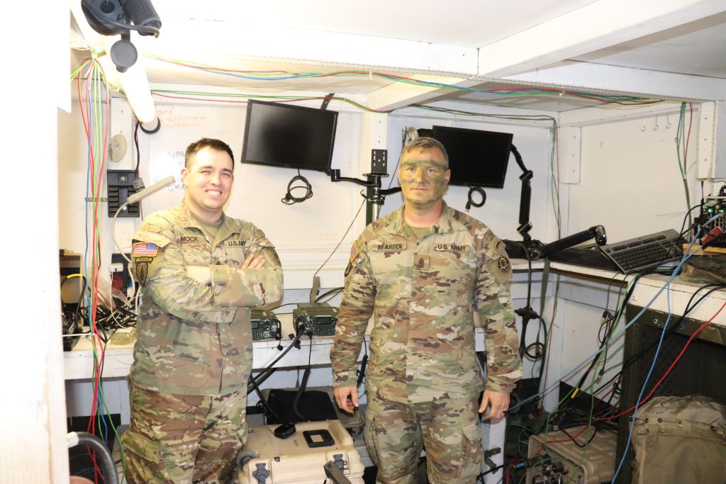 ONLY THE BEST: Staff Sgt. John Mock and Sgt. Maj. Christian Bearden meet in the command post during the unit’s live fire exercise to discuss the concurrent Ops Demo Phase 1. “If the radio is the most casualty producing weapon on the battlefield, we must have a radio that provides the capabilities that we need,” Bearden said. (Photo by Kathryn Bailey, PEO C3T Public Affairs)