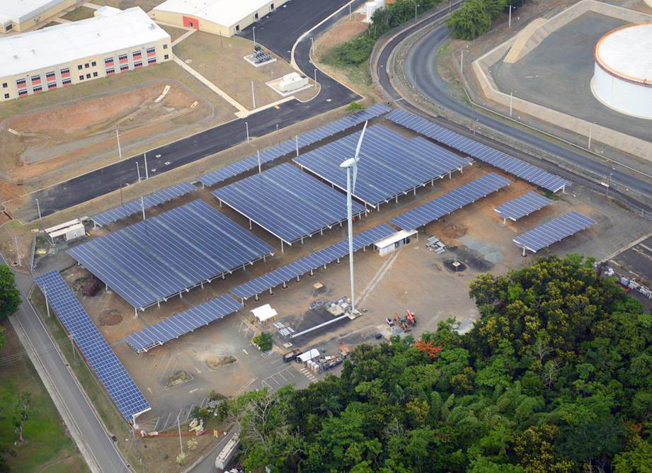 POWER THROUGH WIND: One of two wind turbines stands next to one of its many solar installations on Fort Buchanan, Puerto Rico. The two wind turbines will produce an estimated 5% of the energy consumed by the installation. A total of 21,824 solar photovoltaic panels will produce about 5.5 megawatts of power, which is at least 60% of the installation’s current power demand at its peak production. (Photo courtesy of U.S. Army Engineering and Support Center ‒ Huntsville)