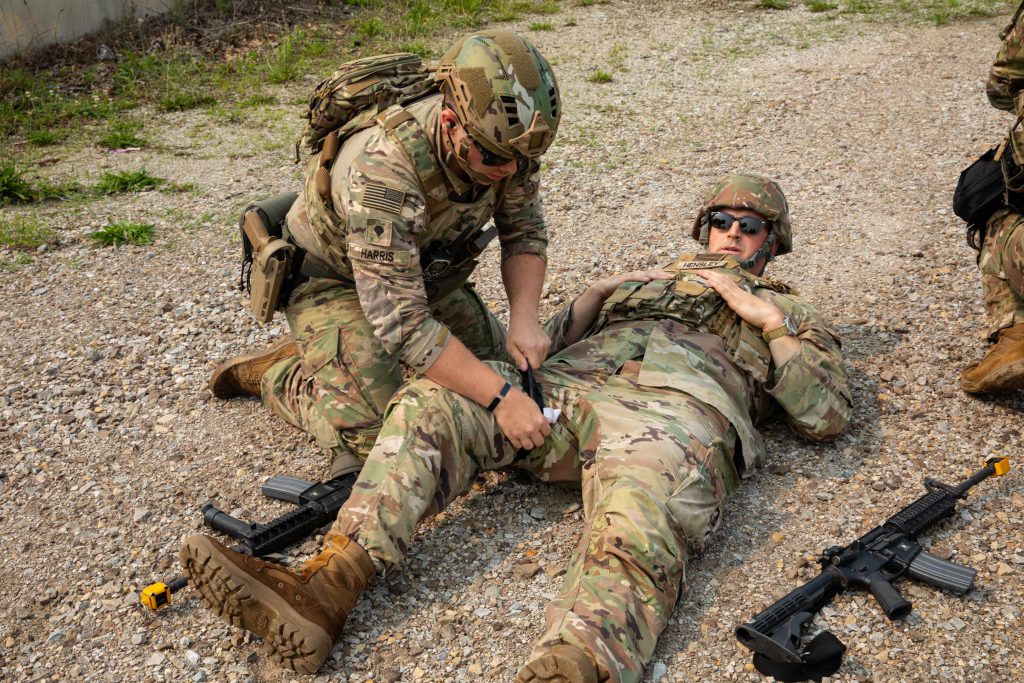 LIFESAVING DATA: U.S. Army Reserve Spc. Matthew Harris, left, assigned to the 412th Civil Affairs Battalion, applies a tourniquet to 2nd Lt. Jarrad Hensley during a simulation training exercise at Operation Viking in Muscatatuck, Indiana, July 16, 2023. Predictive logistics can prevent units from being fatally unprepared. (Photo by Sgt. Alexander Kelly, U.S. Army Reserve)