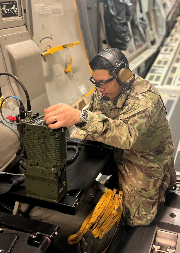 RIGGING THE PLANE: The author, a signal officer for the 2/11 IBCT(A), conducts plane-to-plane radio tests on an installed AN/PRC-158 Mobile User Objective System-capable radio in preparation for an eight-hour cross-Pacific joint forcible entry operation during Arctic Aloha 2024. (Photo courtesy of 2/11 IBCT(A))