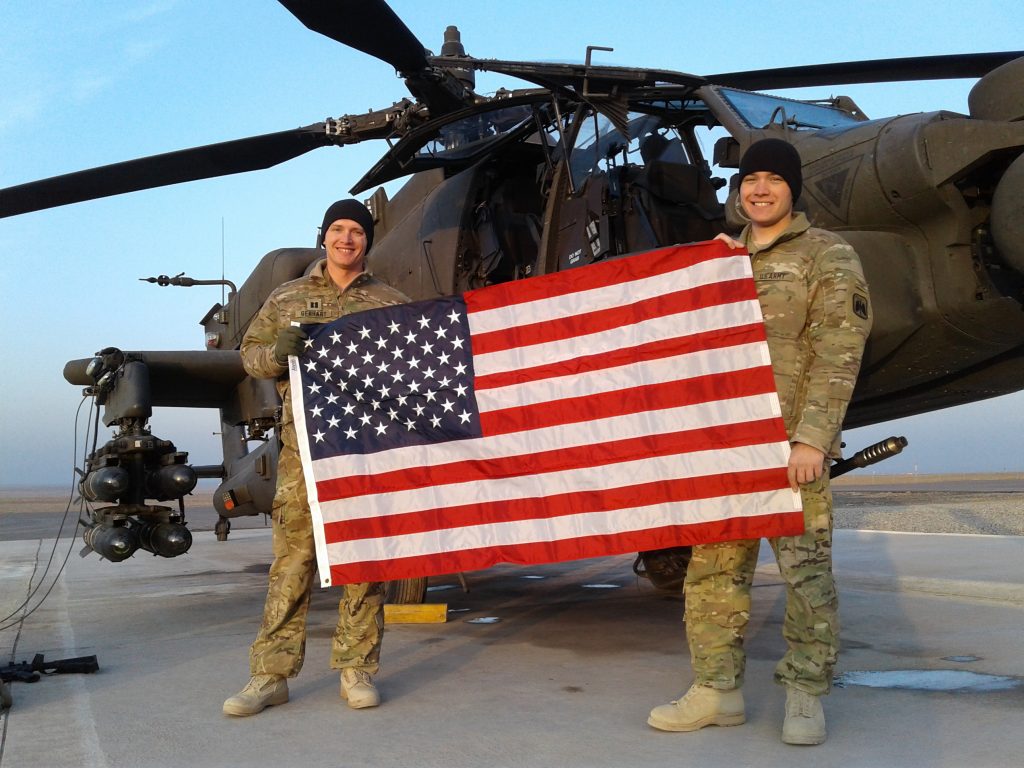 A PATRIOTIC PERSPECTIVEThen Capt. Lucas Gebhart, left, and 1st Lt. Matthew DiPinto stand with the American Flag in Erbil, Iraq, in January 2017. Gebhart helped his organization synchronize several years of maintenance with a busy training schedule. (Photo provided by Maj. Lucas Gebhart, ATEC) 