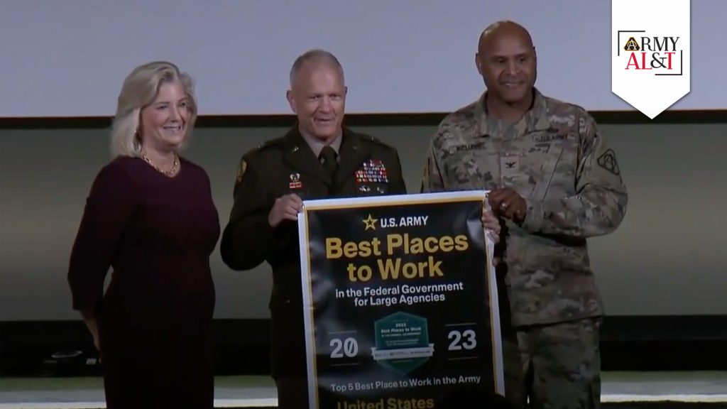 TOP 5 BANNER PRESENTATION Secretary of the Army Christine Wormuth presented Best Places to Work banner to Lt. Gen. Robert M. Collins, military deputy director, ASA(ALT), middle, and Col. Barry Williams, deputy director, USAASC, at the Army Civilian Showcase portion of the 2024 AUSA Annual Meeting and Exposition on Oct. 16, 2024, in Washington. (Photo by Holly DeCarlo-White, USAASC)