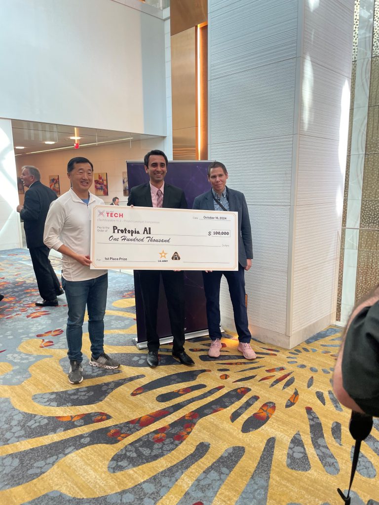 AI WINS: Young J. Bang, left, principal deputy assistant secretary of the Army for acquisition, logistics and technology presents the first-place check for $100,000 to Balaji Chandrasekaran, middle, vice president of go-to-market and customer enablement of Protopia AI with Matt Willis, right, director of Army Applied SBIR and Prize Competitions at AUSA, Oct. 16, 2024. (Photo by Holly Comanse, USAASC)