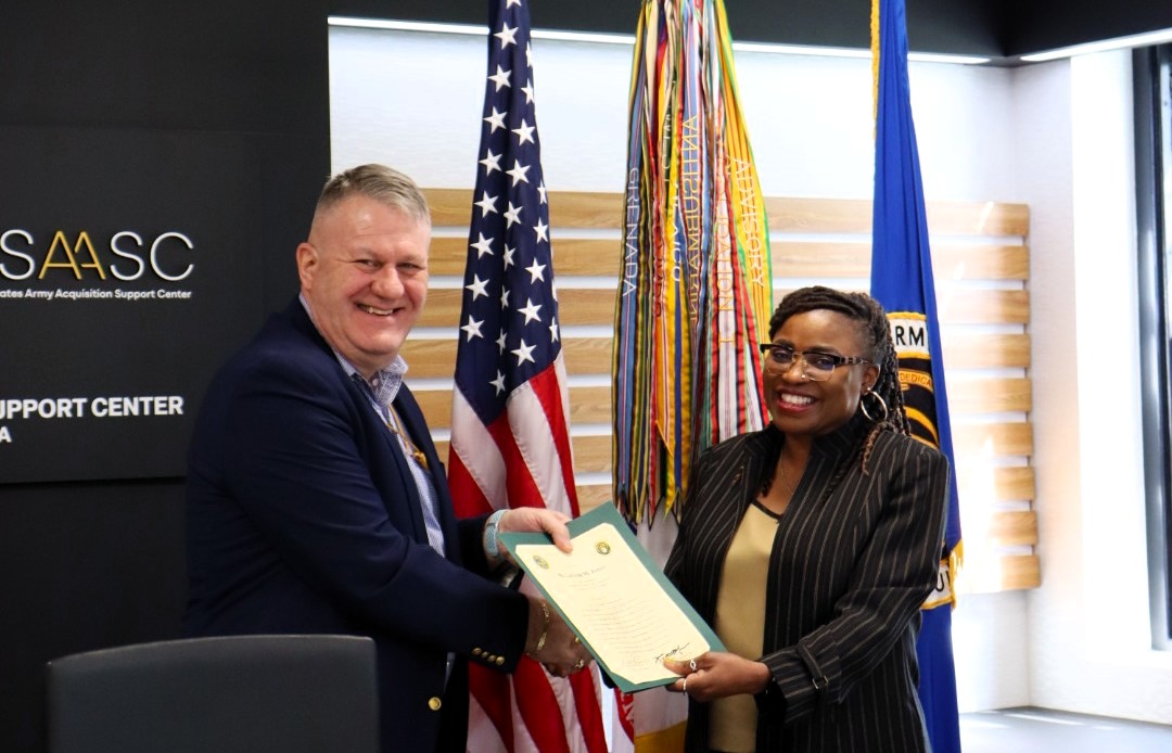 LEAD-Certificate-Acceptance, Caption: Kim S. Gibbons, LEAD Program Manager, accepting certificates on behalf of the graduates from Mr. Rob Richardson, Director of Acquisition Career Management (DACM).