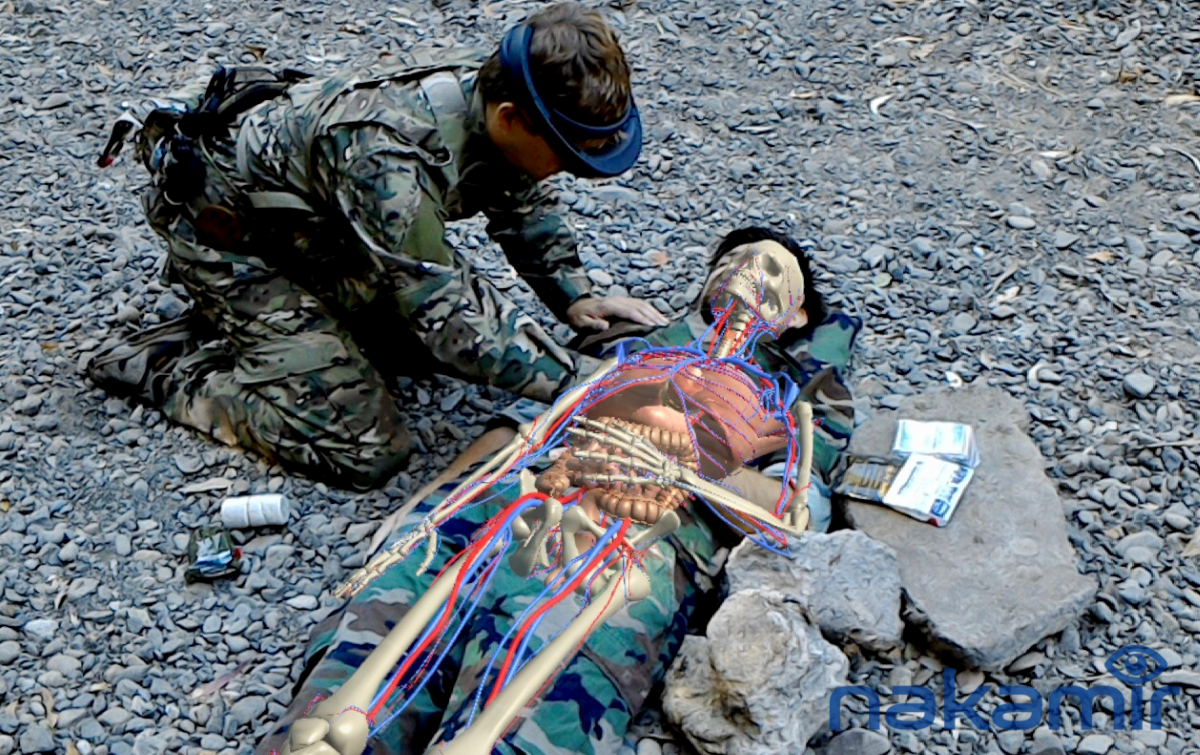 IN FULL VIEW: In a simulation, a medic initiates treatment of a wounded warfighter with IVAS augmented reality software, overlaying the skeleton and cardiovascular system on the display view of the warfighter. (Photo courtesy of Christoph Leuze, Nakamir, Inc.)