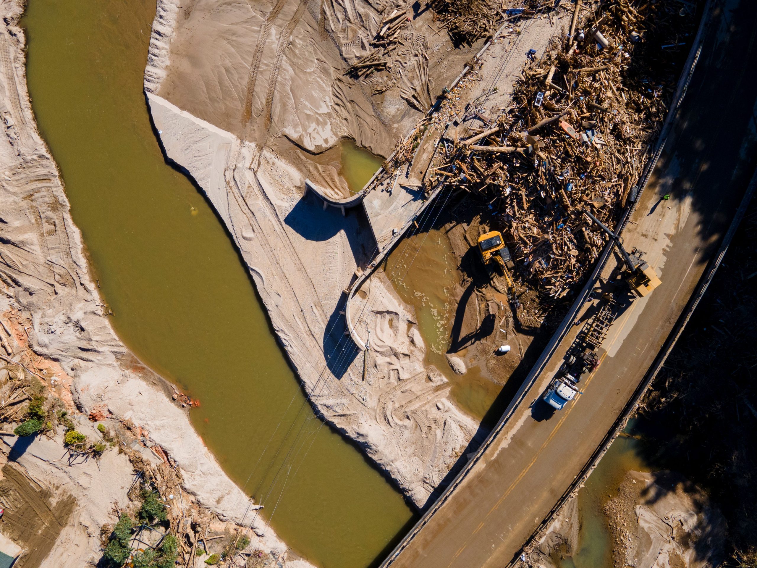 DISASTER RELIEF: Construction vehicles remove debris from a bridge damaged by Hurricane Helene near Chimney Rock, North Carolina, on Oct. 10, 2024. The U.S. Army Corps of Engineers coordinates with a contractor to deliver generators provided by the Federal Emergency Management Agency at critical facilities, such as temporary shelters and water resource stations. (Photo by Michel Sauret, U.S. Army Corps of Engineers)