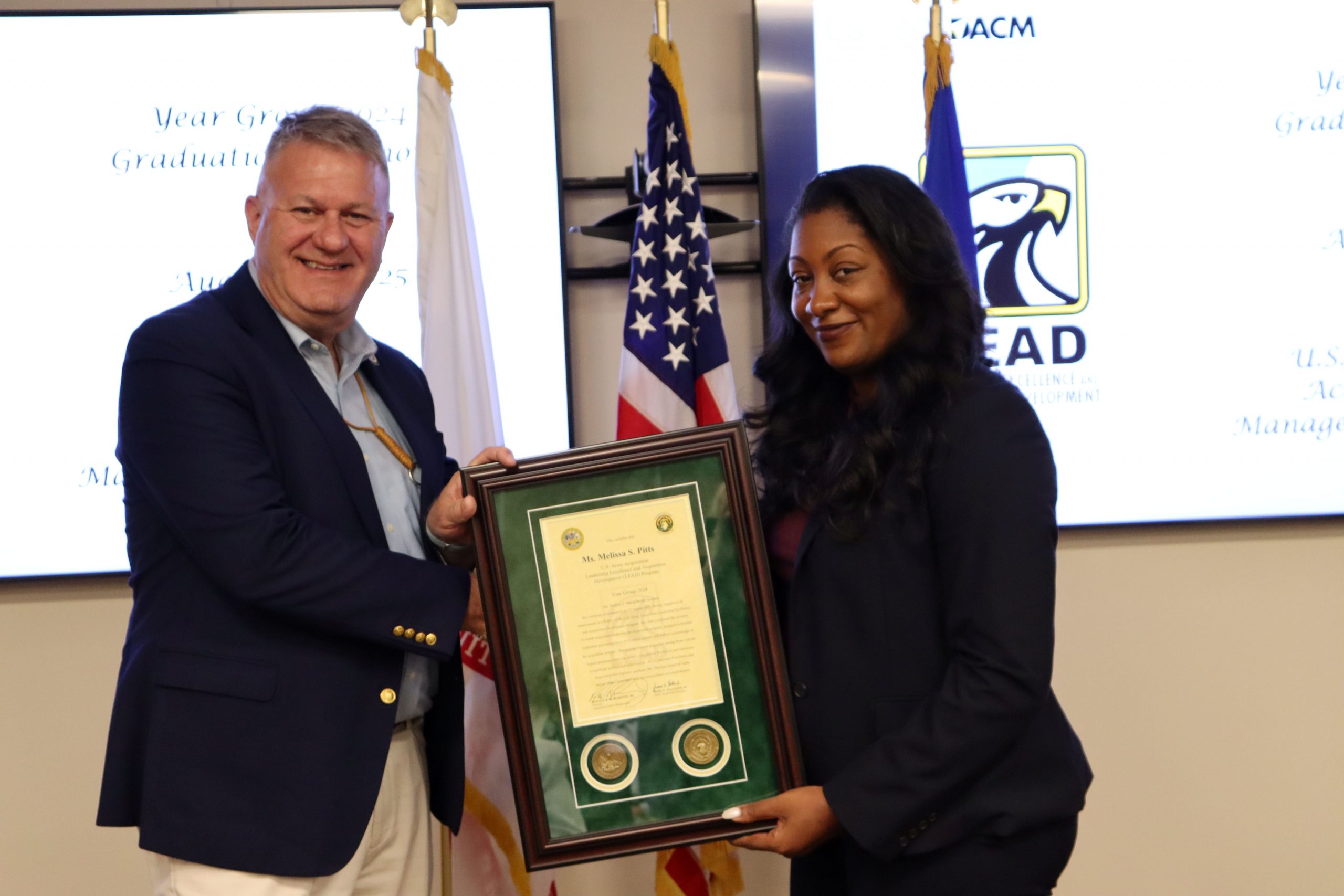 PROUD MOMENT:Melissa Pitts, JPEO CBRND, receives her graduation certificate from Ronald “Rob” Richardson, Jr., Army DACM and director of USAASC.