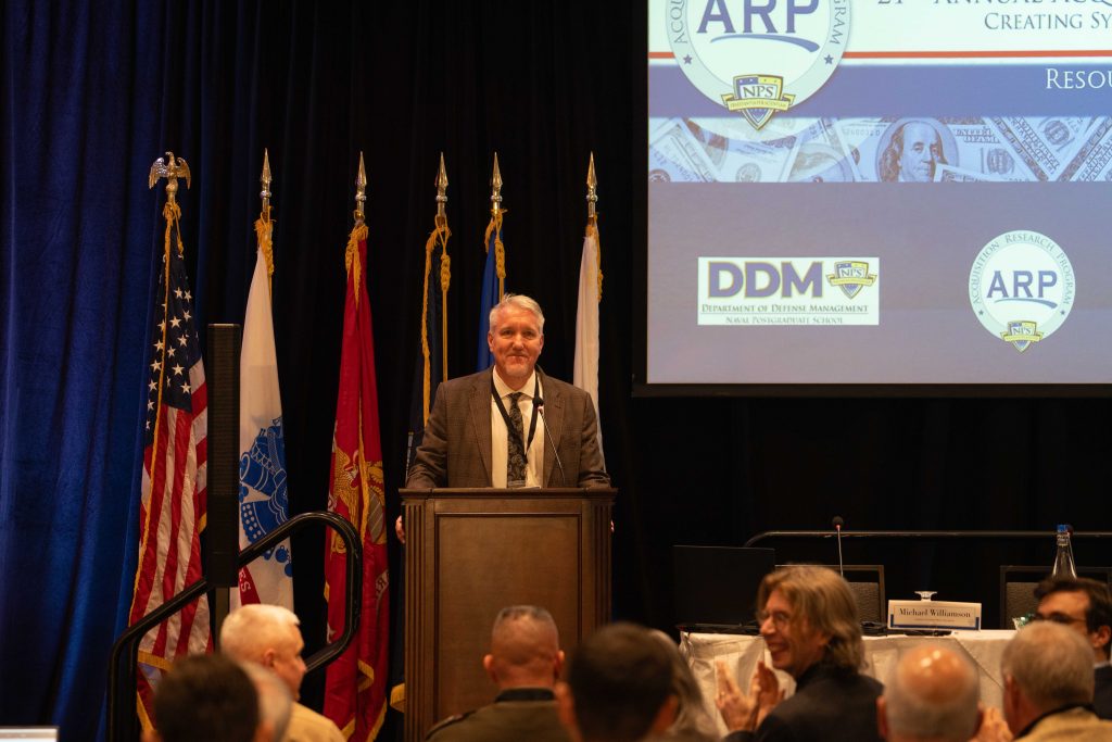 Robert Mortlock, Ph.D. offers administrative remarks during the final day of the NPS Acquisition Research Symposium